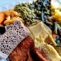 Feast for one! Not pictured are the diced tomatoes with onion, packaged separately, and lentil samosa appetizer. I will be craving this injera bread! at Rahel's Vegan Cuisine in Los Angeles