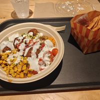 Falafel bowl topped with garlic dressing, with cinnamon sugar pita chips at CAVA - Orlando in Orlando