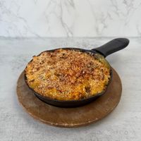 Aisha’s Vegan Mac and Cheese: Creamy, dairy free mac & Cheese topped with cheddar style cheese, panko breadcrumbs and baked to a golden brown.  at Aisha's Plant-Based Eatery in Miami