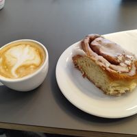 Vegan cappuccino and vegan cinnamon roll at Café DOX  in Prague