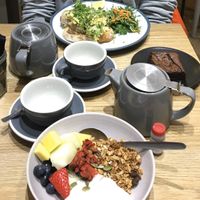 Coconut youghurt with fruit and granola on front. Scrambled eggs and (not vegan) brownie in the back. Nice flavourful teas!  at Kin Cafe Vegetarian in London