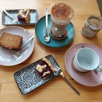 Drei Stück vegane Kuchen, ein Chai Latte mit Hafermilch und eine Tasse für Filterkaffee. at Café Frau Elster in Nuremberg