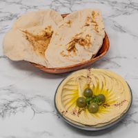 Authentic Syrian hummus served with freshly baked Arabic bread, a creamy and vegan-friendly Middle Eastern favourite. at Damastique in York