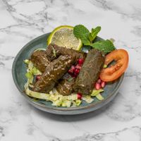 Hand-rolled vine leaves stuffed with seasoned rice, herbs and spices. A classic Syrian vegan appetiser bursting with flavour. at Damastique in York
