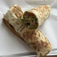 Inhouse made Falafel mix Baked on bread with Tomatoes, pickles, lettuce, tahini & Harrissa  at TA'MINI LEBANESE BAKERY in London