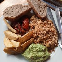 Tofu, toast, stewed tomatoes, guacamole, and potatoes.  Such a good breakfast. at Mandarina in Quetzaltenango