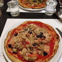 Vegan pizza with cheese (made from lentils), pesto, mushrooms and olives (added as extra) at La Colubrina in Milan