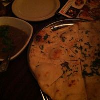 Bhartha Dip - Clay oven roasted eggplant blended with spices and cooked with peas, tomatoes, and served with naan bread at Annapurna Cafe in Seattle