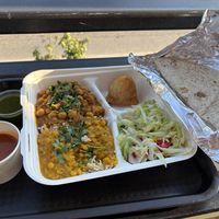 Platter with half chickpeas and half lentils, samosa, rice, and salad; staff is glad to substitute vegan roti for nonvegan naan.  at Yossi Kitchen in Athens