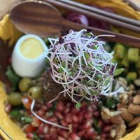 Mediterranean falafel bowl. Hummus, olives,  tomatoes with greens. I liked pomegranate and the dressing was pretty nice too.    at Roots Plant-based Cafe - Hẻm 41 Xuan Thuy in Ho Chi Minh City