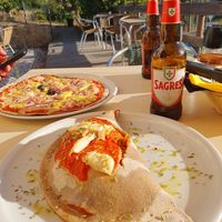 Vegan Calzone with almond cheese, non-vegan tuna pizza in the background  at Trigo Vermelho in Aljezur