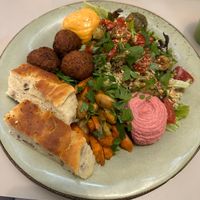 Focaccia, falafel, hummus, quinoa salad, pesto roasted potatoes, marinated tomatoes, aioli, roasted fennel + carrots  at Roots Kitchen in Turku