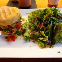 Vegan burger with spelt herb roll, falafel patty, avocado cream, caramelized onions, vegetable cubes and salad at Frucht and Genuss in Dusseldorf
