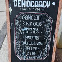 Sign says Proudly Vegan, but the restaurant serves 2% dairy milk and honey inside…  at Democracy* in Hamilton