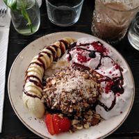 American pancakes (gluten free) with chocolate sauce and nuts - and whipped coconut cream, dried berry pieces, coconut flakes, fresh banana and strawberry. at Fern & Fika in Stockholm