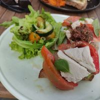 Broodje caprese: Mozzarella van cashewnoot, doperwten pesto, knolselderij ham, rucola, olijf, tomaat, zonnebloempitten, balsamico, brood at GYS - Voorstraat in Utrecht