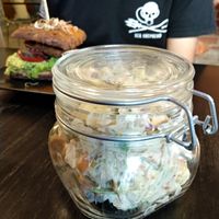 Estonian potato salad and behind that, a burger. The salad has apple and vegan sausage pieces too. Excellent. at Vegan Inspiratsioon in Tallinn