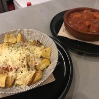 Patatas con baicon y queso y albóndigas en salsa at El Oju in Granada