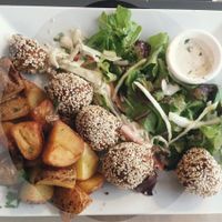 Roasted potatoes, sesame and rice balls, salad and sauce at Mezzaluna in Saint-laurent-blangy