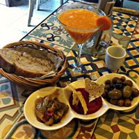 Three different types of tapas (olives, beetroth hummus and mixed veggies) and fresh juice at VEGA - Luna in Madrid