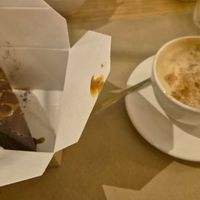 Chocolate cake to go as I was too full. Wonderful café con leche. at Punto Vegano in Madrid