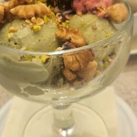 Vegan Ice Cream cups with one scoop of raspberry-chocolate, one scoop of hazelnut and two scoops of pistachio ice cream. Topped with different kinds of nuts. at Vanilla Gelati Italiani in Milan