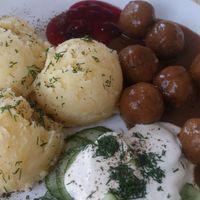 Potato puree with dill, cranberry sauce, cucumber salad and Polish version of meat balls - 'klopsiki'. The dish is called KLOPSIKI. at Lokal Vegan Bistro in Warsaw