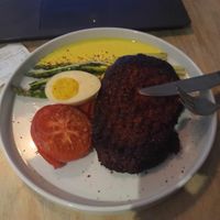 Seitan steak & plant-based egg, roasted tomato and asparagus at Lokal Vegan Bistro in Warsaw