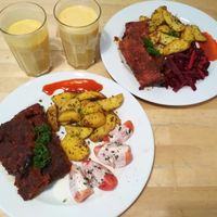 BBQ "Ribbs" (the top right contains its original vegetable side dish - beetroot - the bottom left has the vegetable side dish switched to tomatoes) and 2 cups of mango lassi, as served in October 2018. at Lokal Vegan Bistro in Warsaw