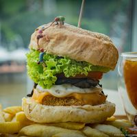Lion’s Mane Extreme Burger with salad & fries and comes with a Lemon Passion Fruit Tea  at nomVnom Bistro - Clarke Quay in Central Singapore