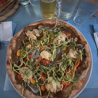 Pizza con crema di melanzane, falde di peperoni, cipolla ripassata, ricotta di mandorle alle olive verdi e carpaccio di zucchine marinate. at Pizzeria Capri in Jesolo