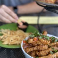 Front and focused is the Orange Chick’n Bowl. In the background is their fries being dipped in their tasty house made fry sauce and the Chick’n Bacon Ranch pizza. at Allie's Vegan Pizzeria and Cafe in Spokane
