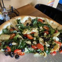 Design your own pizza - spinach, basil, olive, artichoke hearts, and cherry tomatoes. Olive oil and garlic sauce and Daiya cheese on their vegan crust. So delicious ! at Rosie's Pizzeria in Pagosa Springs
