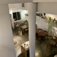 View coming down the stairs from the toilets and upstairs seating. Has a small balcony upstairs which is nicely decorated with plants as is the rest of the establishment.   at Backyard Cafe - Riverside in Phnom Penh