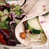 Grilled chickpea wrap with oriental spices, tomatoes, cucumbers, salad, “Feta” sauce, chives, lime and raw vegetable salad at Les Demoiselles de Montpellier in Montpellier