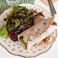 Grilled chickpea wrap with oriental spices, tomatoes, cucumbers, salad, “Feta” sauce, chives, lime and raw vegetable salad at Les Demoiselles de Montpellier in Montpellier