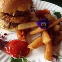 Vegan burger and chips with cute editable flowers at Super Natural in Newcastle Upon Tyne