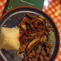 Lomo saltado, Peru's national dish: seitan-like stir-fried strips with onion and mushroom in a hearty brown gravy, flavored with a touch of soy sauce. Also pictured: vegan 'chicharrones', crunchy bites that soak up the fresh pico de gallo. at El Encuentro - Choquechaca in Cusco