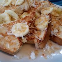 Vegan French Toast with bananas, toasted coconut, and coconut syrup. Amazing! Best I've ever had! at Mesa Cafe in San Pedro