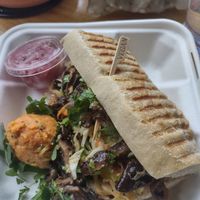 Mushroom banhi mi, w/ potato sald, add pickled oinions. Delicious! I also got a Medicine Mylk, not pictured here, & water.. It was great, but expensive. at Pulp + Sprout Juice Bar and Vegan Cafe in Asheville