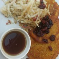 Vegan pancakes with apples, dried cranberries, and maple syrup. at Cafe Mlynek in Krakow