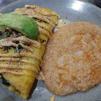 Just Egg and black bean omelette topped with avocado and microgreens with grits. at The Bossy Hen in Myrtle Beach