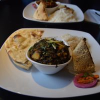 Methi aloo (fenugreek leaves and potato in nutty curry), and mixed vegetable jhal frazi (in the background). Both served with roti, rice, and a papadum cone. SO TASTY. at Moksha Indian Bistro in Niagara Falls