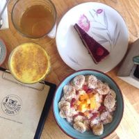 Golden milk cappuccino, porridge, raw raspberry tart, sensha tea at Vegan Tiger in Berlin