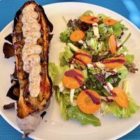 Baked sweet potato stuffed with vegetables topped with aioli and nuts gratin + salad  at Fang i Aram in Menorca