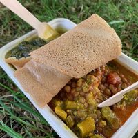Box with a range of curries, spinach, sauces etc, cous cous and injera   at Red Tent Ethiopia in South East London