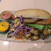 Sandwich de milanesa de seitán con papas al horno, ensalada, y salsa at Veganius in Buenos Aires