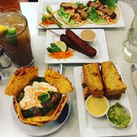 All the goodness: tempeh tacos, tempeh skewers, chana paratha, and their epic cornbread. at Aux Vivres - Comptoir Pret a Manger in Montreal