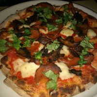 pizza with basil, mushrooms, vegan cheese and vegan meat at Pizza Nea in Minneapolis