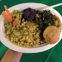 Combination dish: rice, red beans, pea hummus with carrot sticks, purple cabbage hummus, sautéed endive with olives and toasted bread cubes, walnut bread bun at Vegan Store Stall 83 in Rome